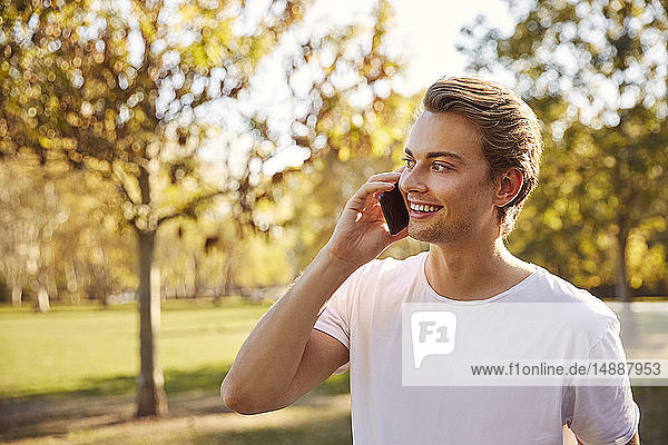 Junger Mann mit Smartphone in einem Park
