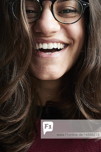 Porträt einer lachenden jungen Frau mit Brille