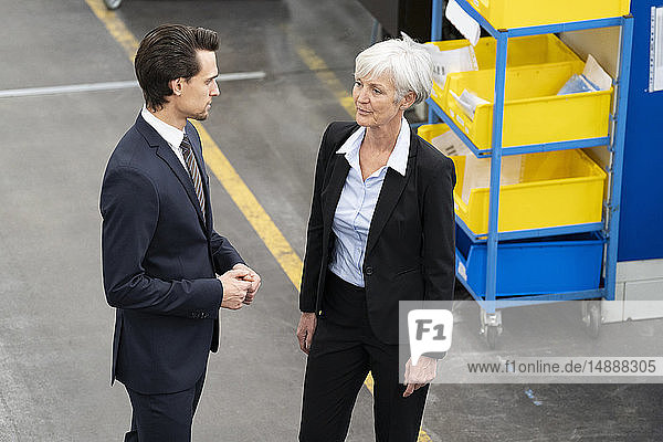Businessman and senior businesswoman talking in a factory