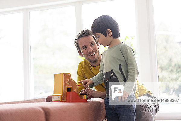 Vater und Sohn spielen mit einer Spielzeugkasse