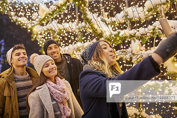 Happy friends in winter decoration taking a selfie