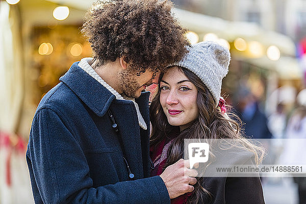 Happy affectionate young couple at Christmas market