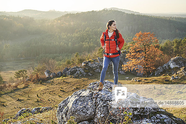 Woman on a hiking trip in the mountains standing on arock
