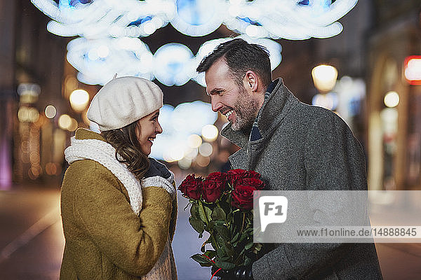 Man gifting his girlfriend bunch of red roses on Valentine's Day