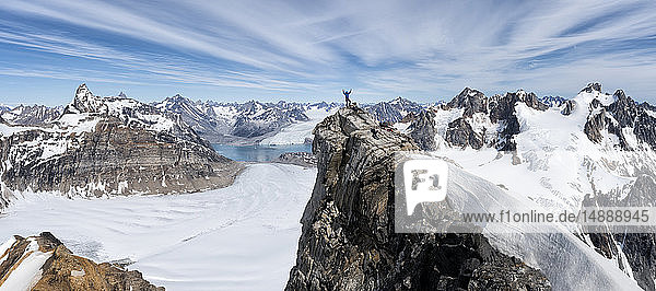 Greenland  Sermersooq  Kulusuk  Schweizerland Alps  mountaineer with raised arms on summit