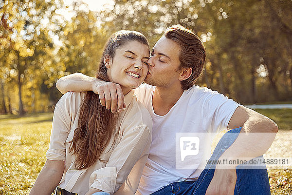 Glückliches junges Paar küsst sich in einem Park