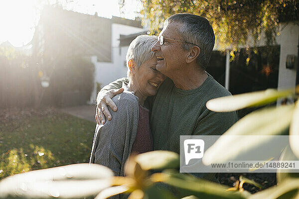 Glückliches  anhängliches Seniorenpaar umarmt sich im Garten