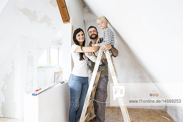 Porträt einer glücklichen Familie  die beim Dachbodenausbau arbeitet