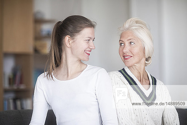 Portrait of smiling mother and adult daughter looking at each other
