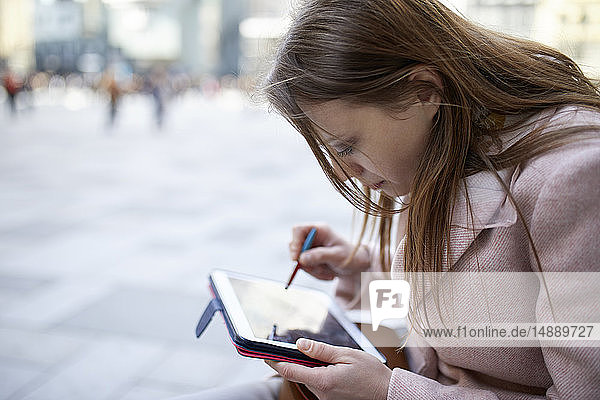 Österreich  Wien  junge Frau mit digitalem Tablet in der Stadt