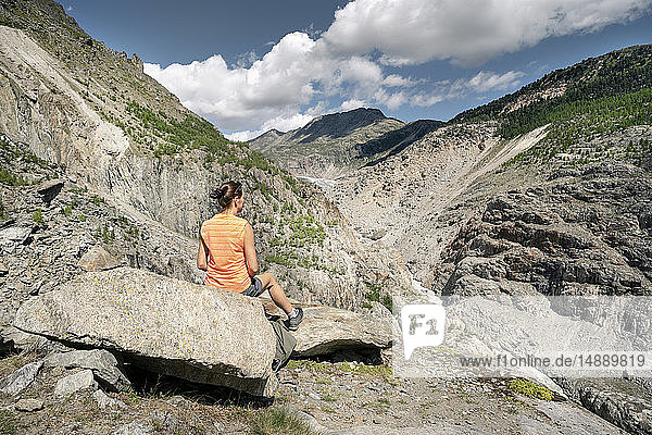 Schweiz  Wallis  Frau ruht sich während einer Wanderung in den Bergen am Aletschgletscher aus