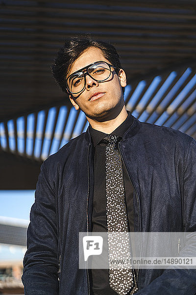 Porträt eines modischen jungen Geschäftsmannes mit Brille und Krawatte