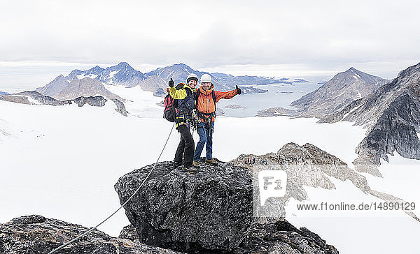 Grönland  Sermersooq  Kulusuk  Schweizer Alpen  Porträt glücklicher Bergsteiger auf dem Gipfel