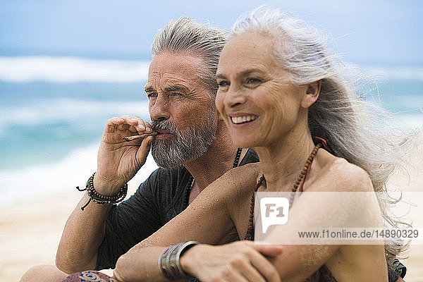 Älteres Hippie-Paar entspannt gemeinsam am Strand