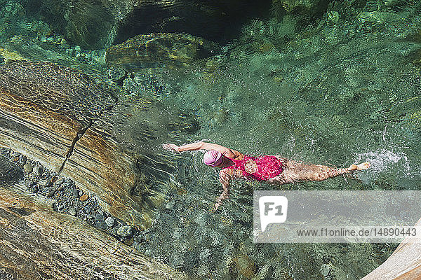 Schweiz  Tessin  Verzascatal  Frau schwimmt im erfrischenden Fluss Verszasca