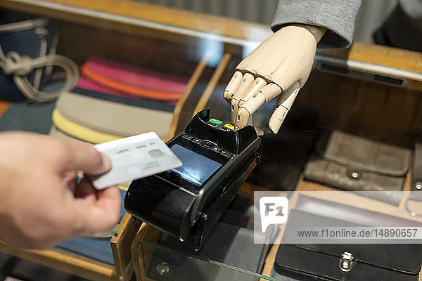 Kunde bezahlt mit Kreditkarte  Roboter assistiert