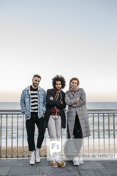 Porträt von drei Freunden am Meer stehend