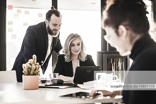 Business people working together in office  businessman watching colleague  looking over shoulder