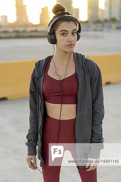 Sportliche junge Frau mit Kopfhörern beim Training