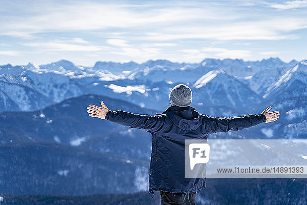 Deutschland  Bayern  Brauneck  Mann im Winter genießt die Aussicht in den Bergen