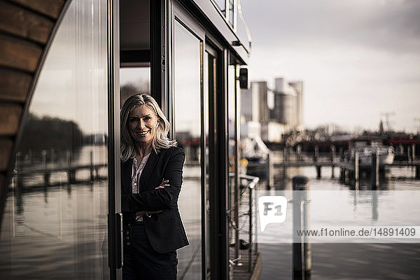 Businesswoman standing on a houseboat  looking out of window