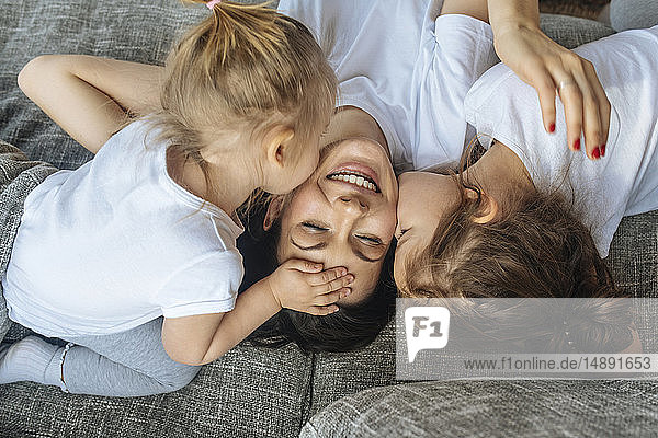 Daughters kissing their mother's cheek
