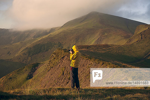 Mann in gelber Jacke beim Fotografieren in den Karpaten