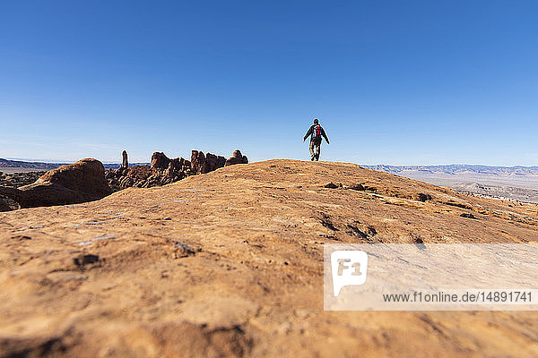 Man hiking on rock in Arches National Park  Utah  USA