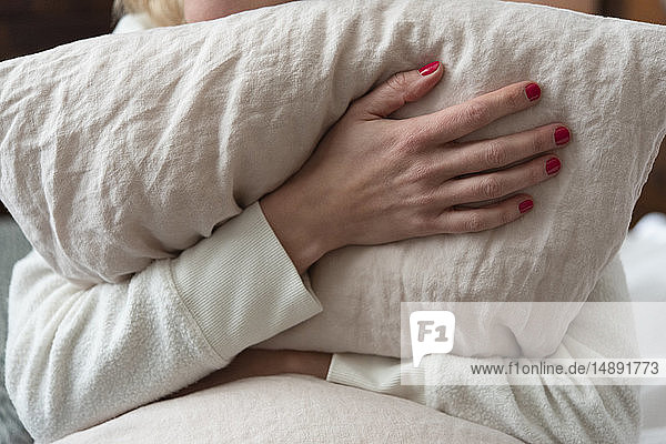 Woman holding pillow on bed