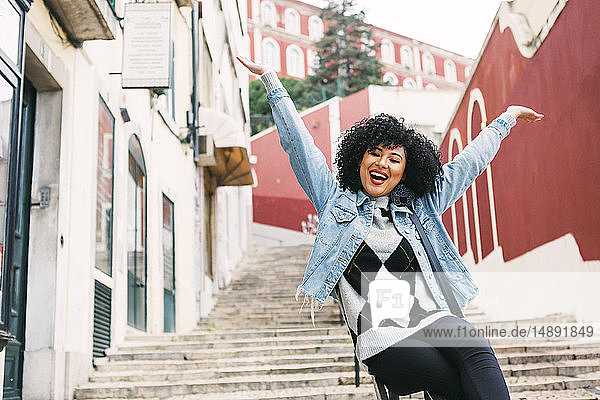 Junge Frau mit erhobenen Armen auf einer Treppe in Lissabon  Portugal