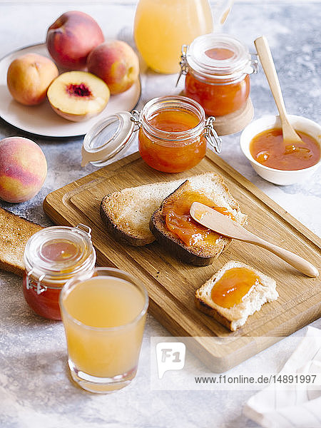 Aprikosenmarmelade auf Toast mit Pfirsichen und Saft