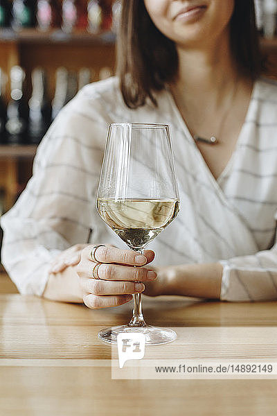 Frau hält ein Glas Weißwein