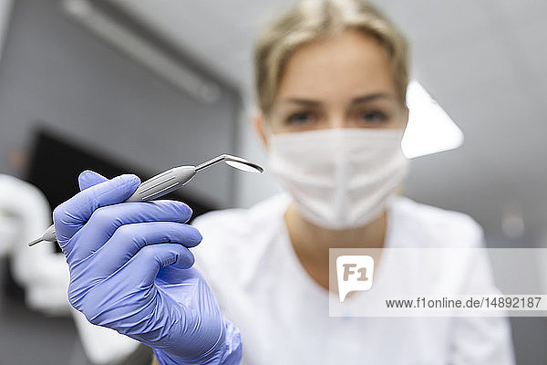 Blick des Patienten auf eine Zahnarzthelferin mit zahnärztlicher Ausrüstung