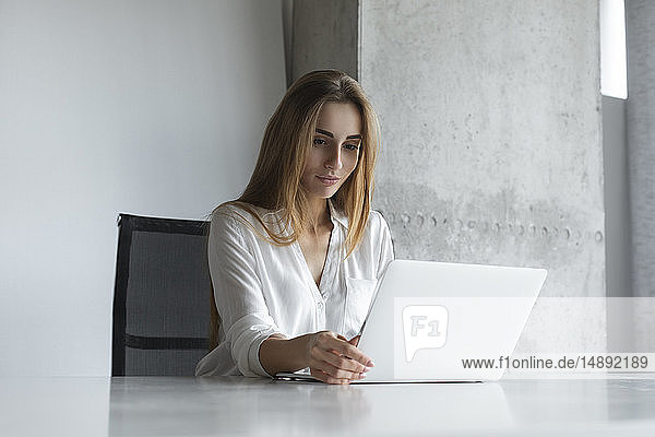 Junge Geschäftsfrau arbeitet an einem Laptop