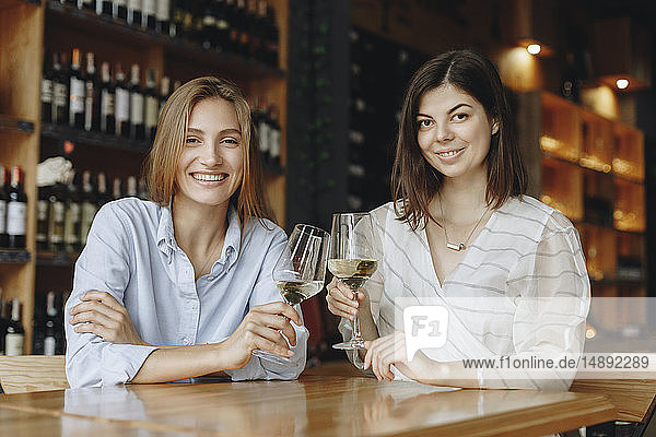 Young women toasting with glasses of white wine