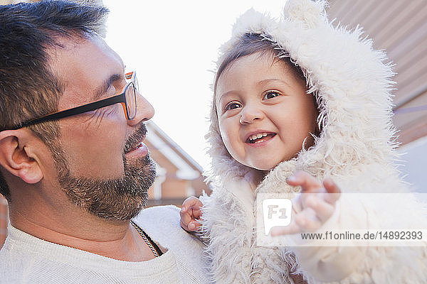 Man holding smiling daughter