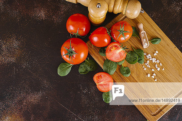 Tomaten  Basilikum und Salz auf einem Holzbrett
