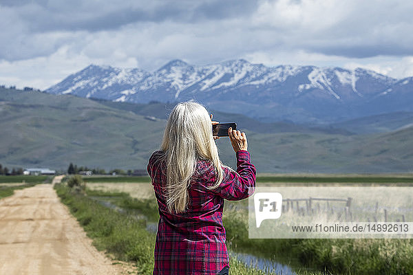 Woman photographing mountains in Fairfield  Idaho  USA