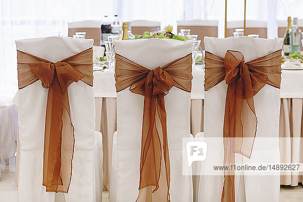 Ribbon tied to dining chairs at wedding