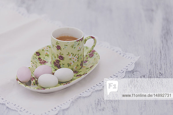 Eier auf Blumenteller mit passender Tasse Tee
