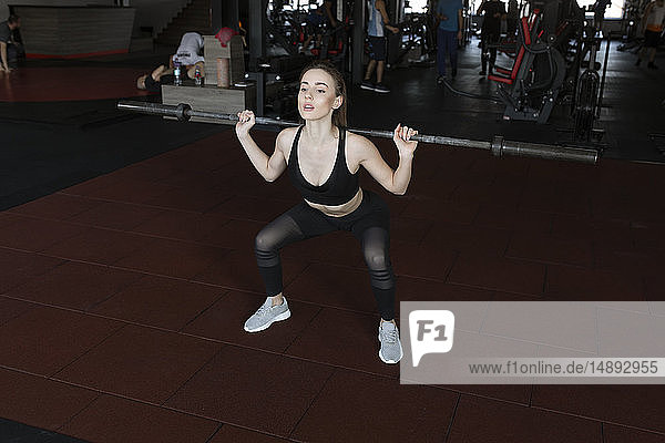 Junge Frau beim Gewichtheben im Fitnessstudio