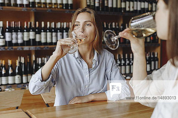 Junge Frauen trinken Weißwein