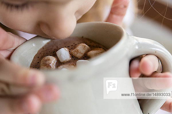 Mädchen trinkt heiße Schokolade mit Marshmallows