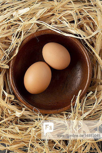 Eier in Holzschale auf Stroh
