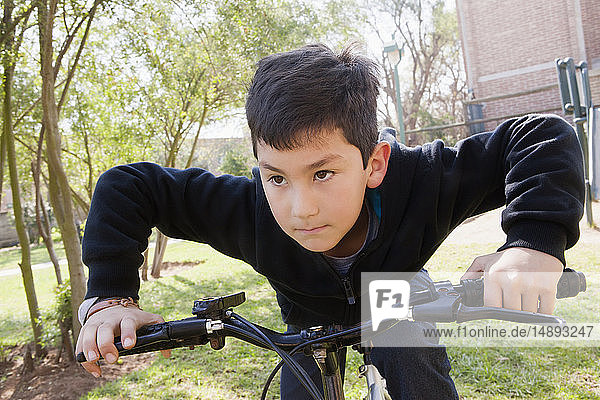 Boy riding bicycle in park
