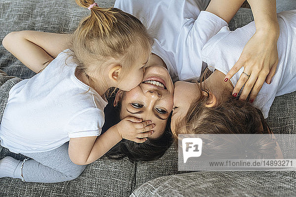 Töchter küssen ihre Mutter auf die Wange