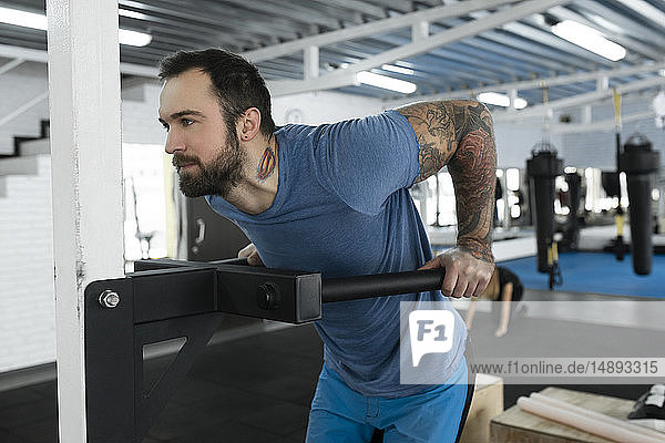 Mid adult man using exercise machine in gym