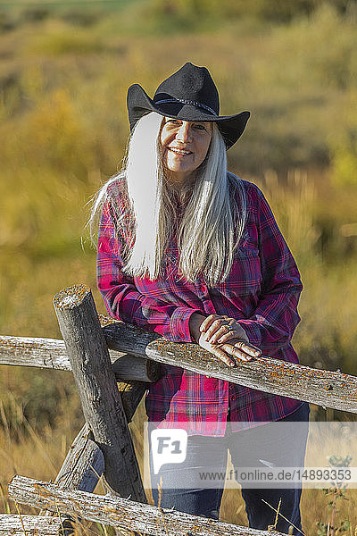 Ältere Frau mit Cowboyhut auf einem Feld