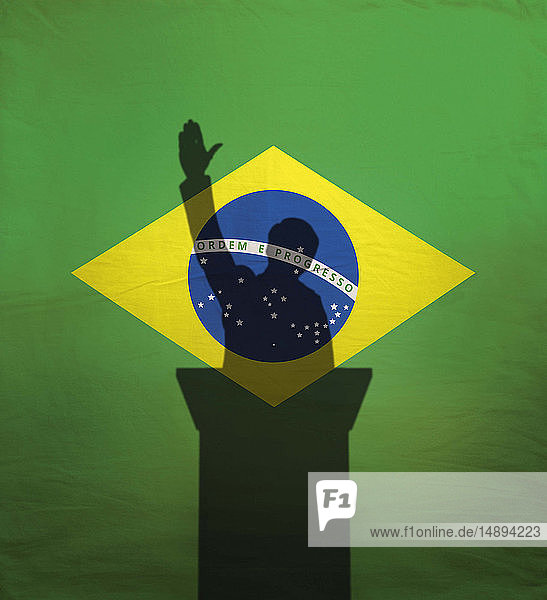Politiker mit erhobenem Arm über der brasilianischen Flagge