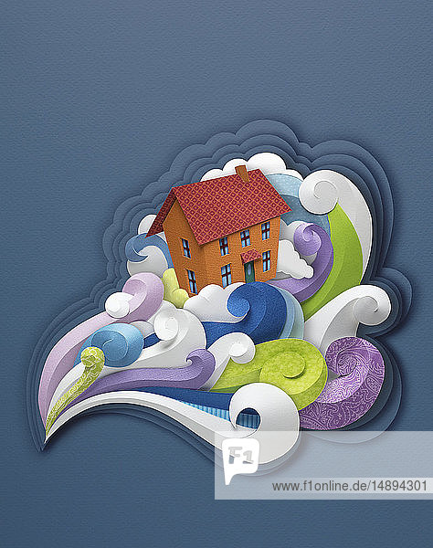 Papierskulptur eines Hauses im stürmischen Wind